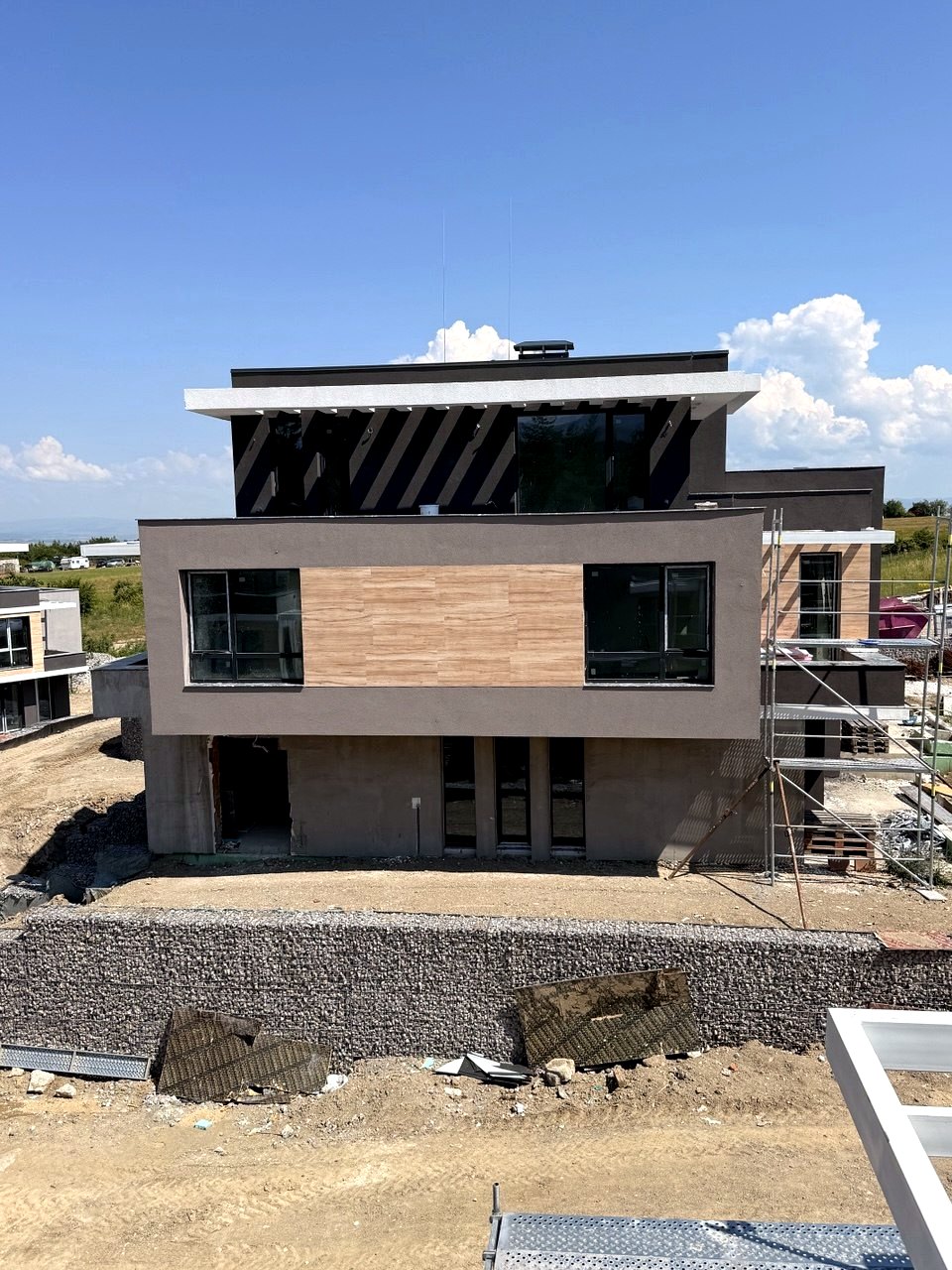 Фасада с дървесен акцент и габионни стени в Alexandria Homes